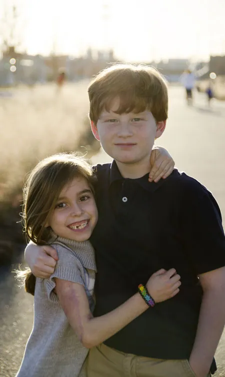 Matthew with his arm around his sister Caroline outdoors, Christmas 2013